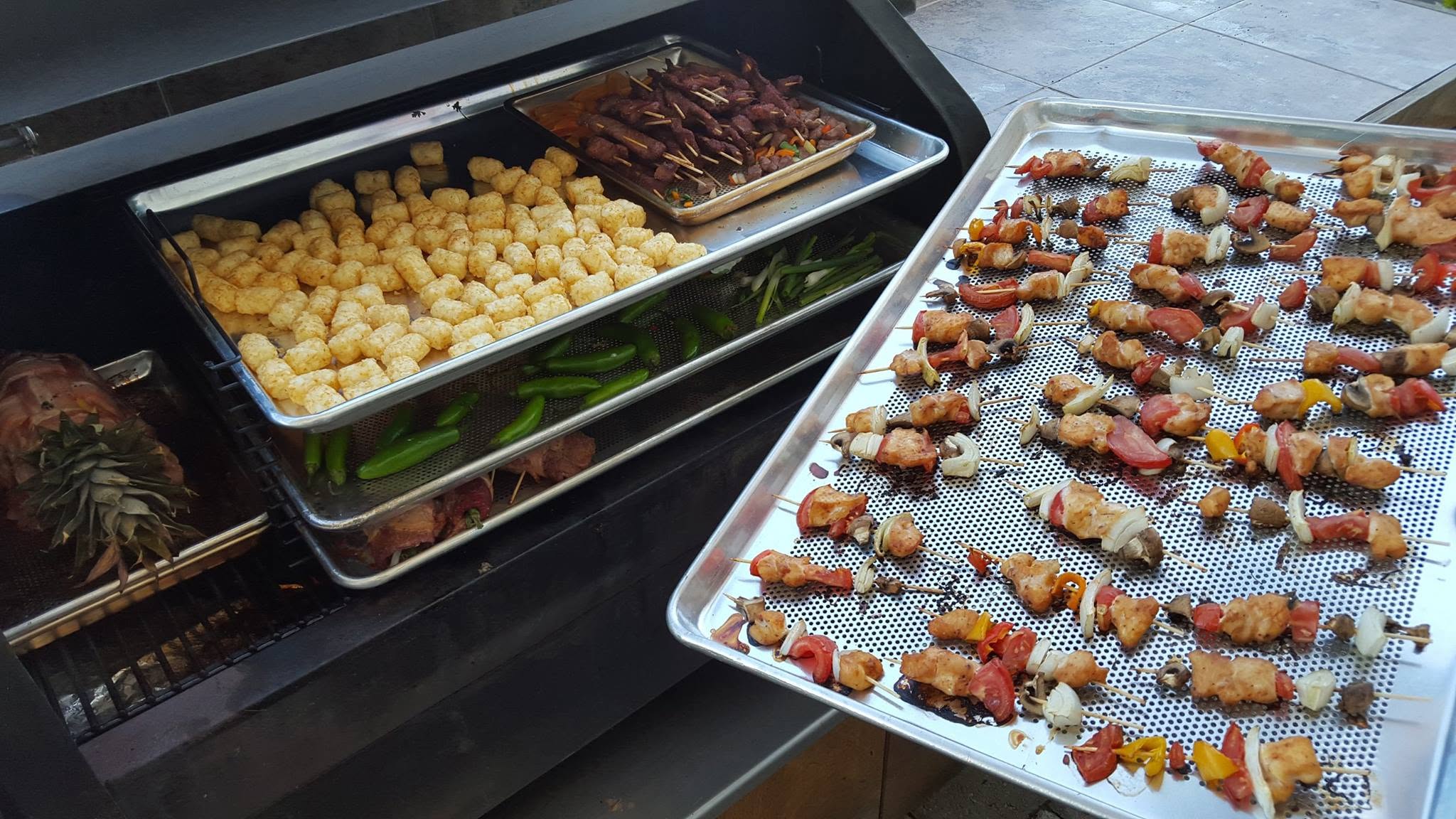 Kabobs, tater tots and veggies filling a Bull Rack on the grill